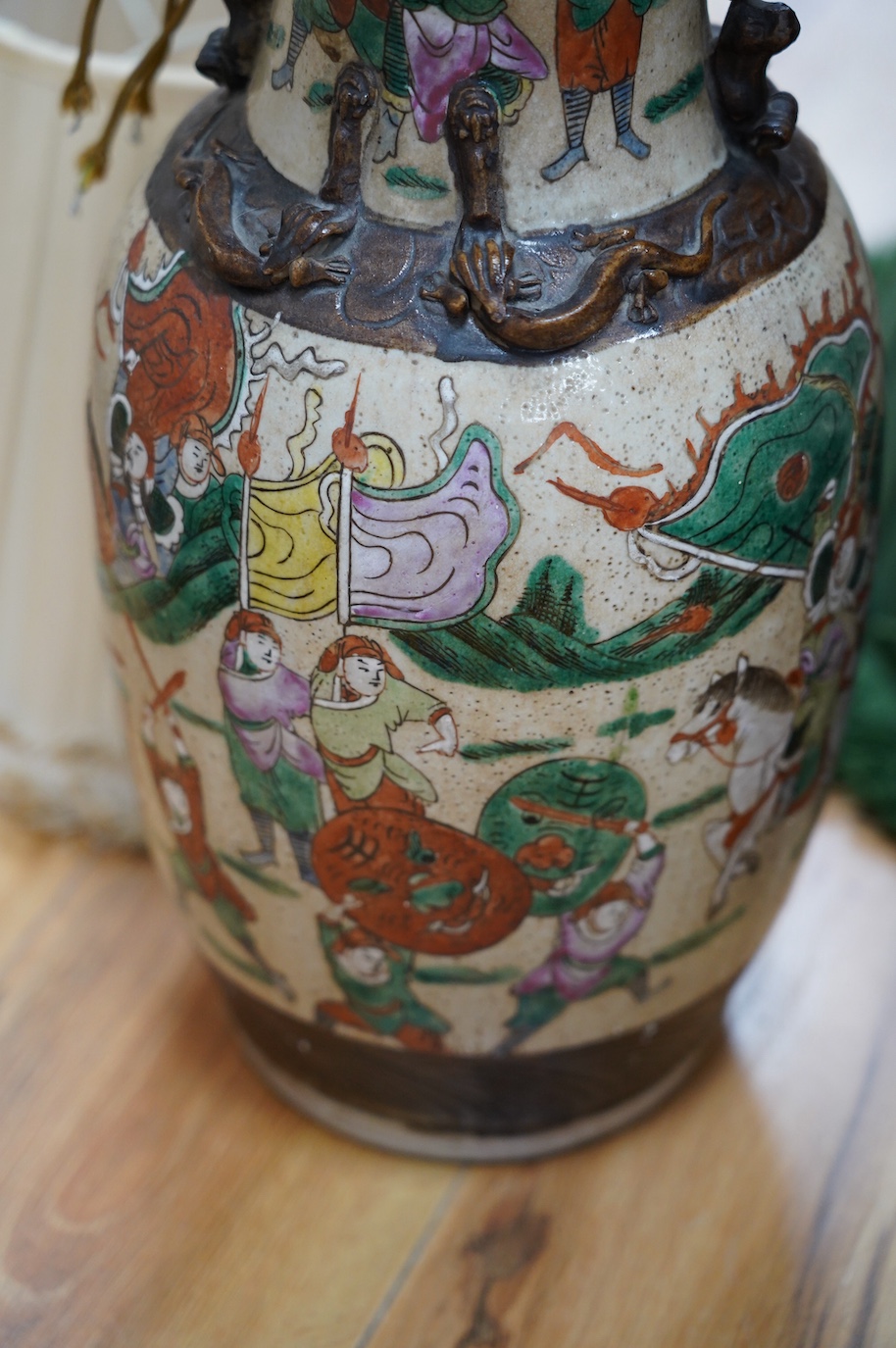 A pair of early 20th century Chinese famille verte crackle glaze ‘warrior’ vases converted to lamps with shades, height 44cm. Condition - fair to good